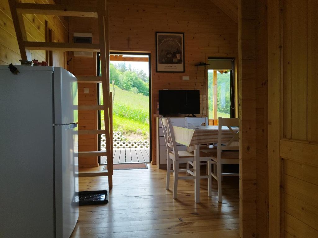 a kitchen and dining room with a table and a refrigerator at Pod Bercem in Solina