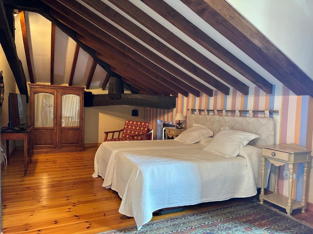 a bedroom with a large bed in an attic at Hotel Palacio La Casona de Cerrazo in Cerrazo