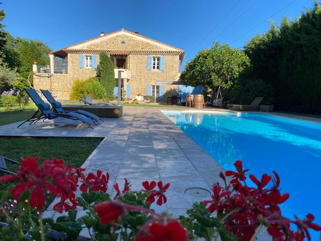 eine Villa mit einem Pool vor einem Haus in der Unterkunft Studio avec terrasse privative et piscine in Grillon