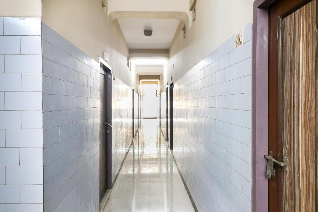 a corridor of a hallway with white walls and a door at OYO Jayanthi Mansion in Chennai