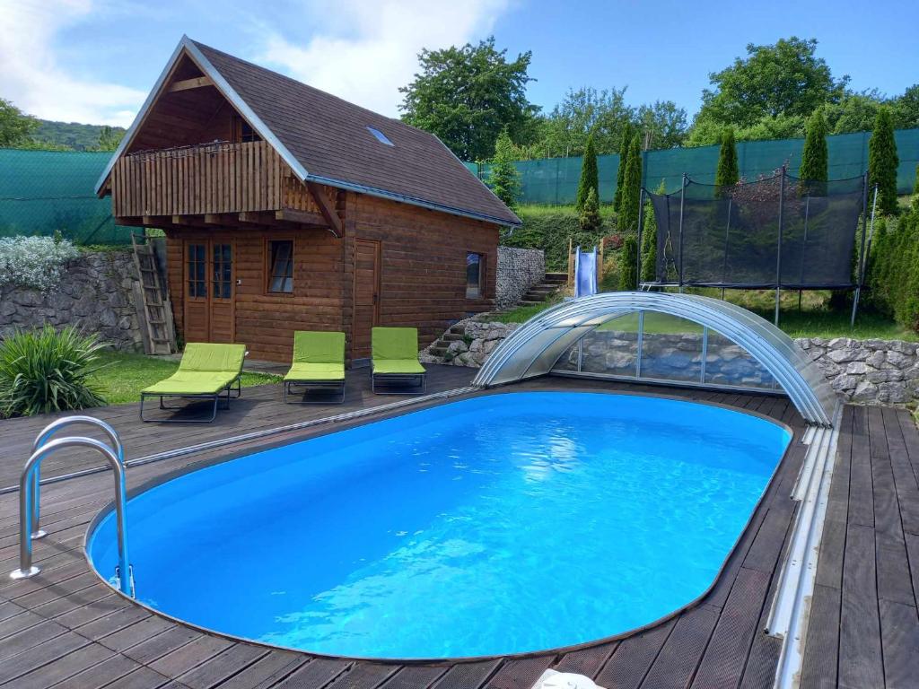 a swimming pool in a yard with a house at Samostatný dom s bazénom v Rajeckej doline 
