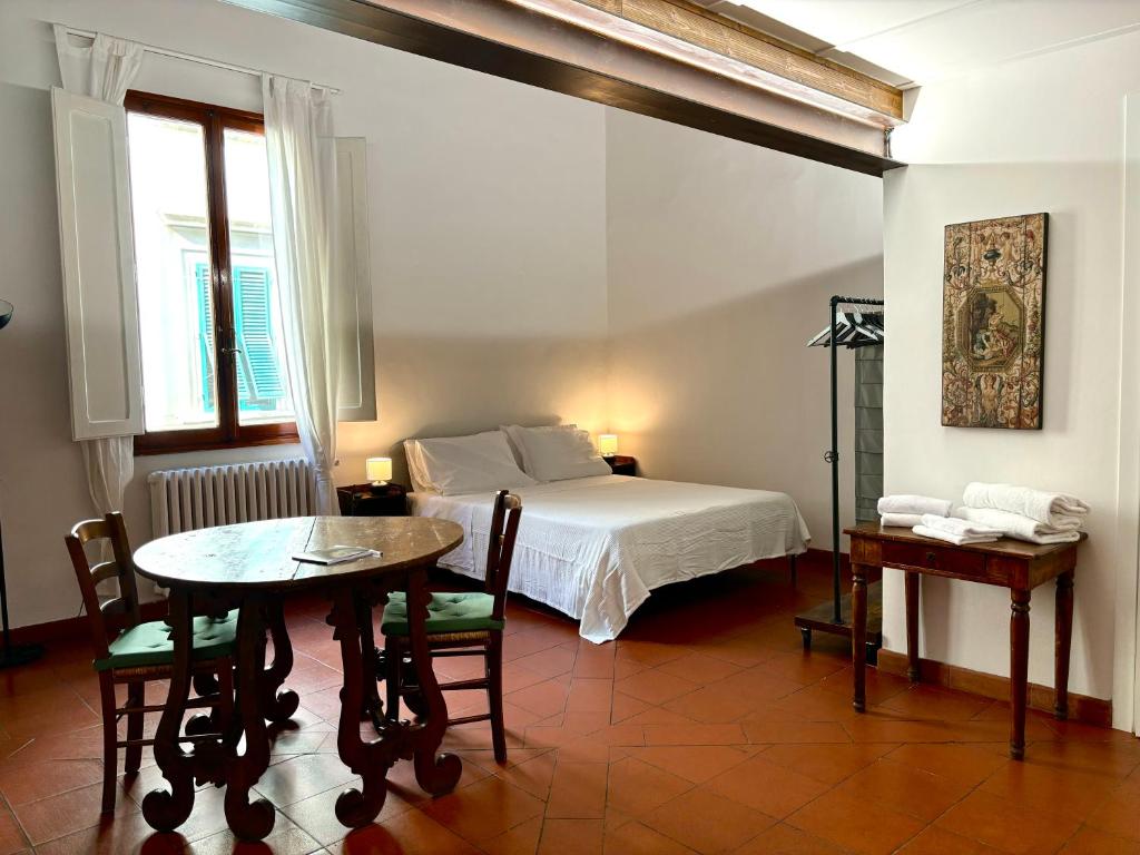 een slaapkamer met een bed en een tafel en stoelen bij Affittacamere Medusa in Florence