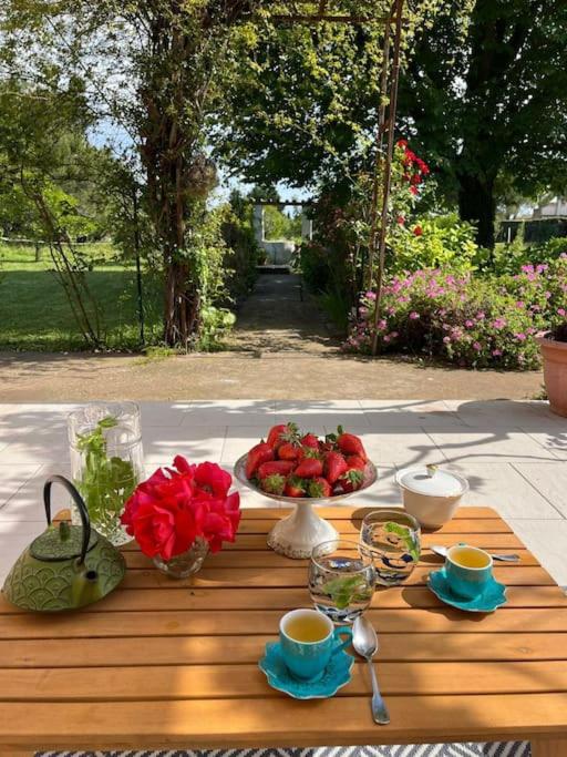 a table with a plate of fruit and flowers on it at Villa Philipp'inn in Arles