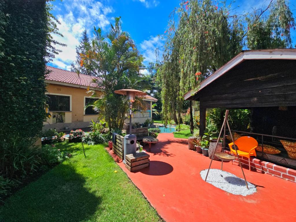 een huis met een rode patio met een parasol bij Mazzola Safari House & Backpacking in Arusha