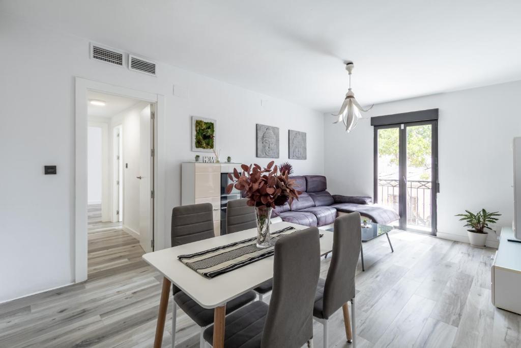 ein weißes Wohnzimmer mit einem Tisch und einem Sofa in der Unterkunft Apartamento moderno a 10 minutos del centro in Ogíjares