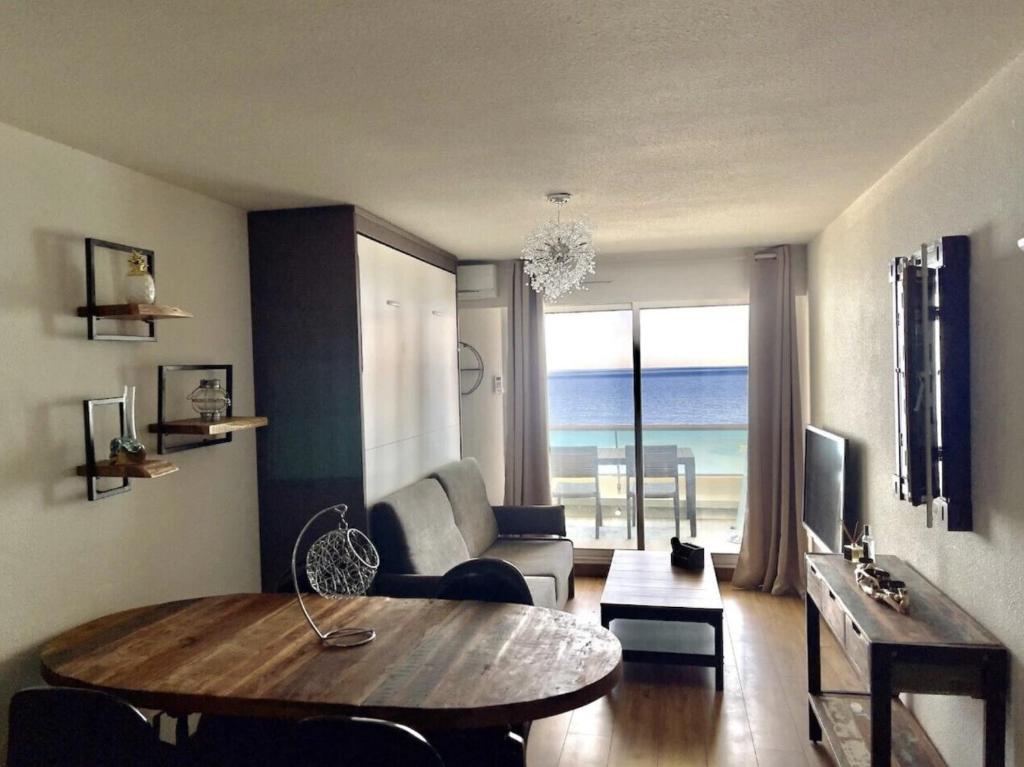 un salon avec une table et un canapé dans l'établissement Sète Plage Corniche, à Sète