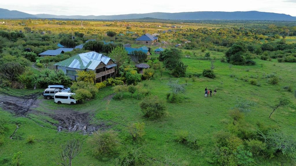 an aerial view of a farm with vehicles parked in a field at Eco mara forest camp in Ololaimutiek