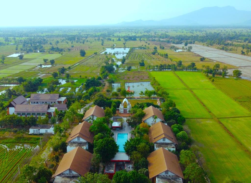 eine Luftansicht eines Dorfes mit Häusern und Feldern in der Unterkunft Sukhothai Treasure Resort & Spa- SHA Plus Certified in Sukhothai