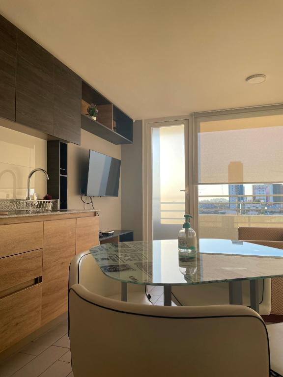 a kitchen with a glass table with a bottle on it at Departamento Tucapel 2 centro de Concepción in Concepción