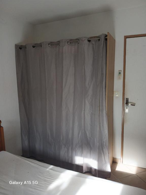 a bedroom with a bed with a gray curtain at CHAMBRE A LOUER Marseille in Marseille