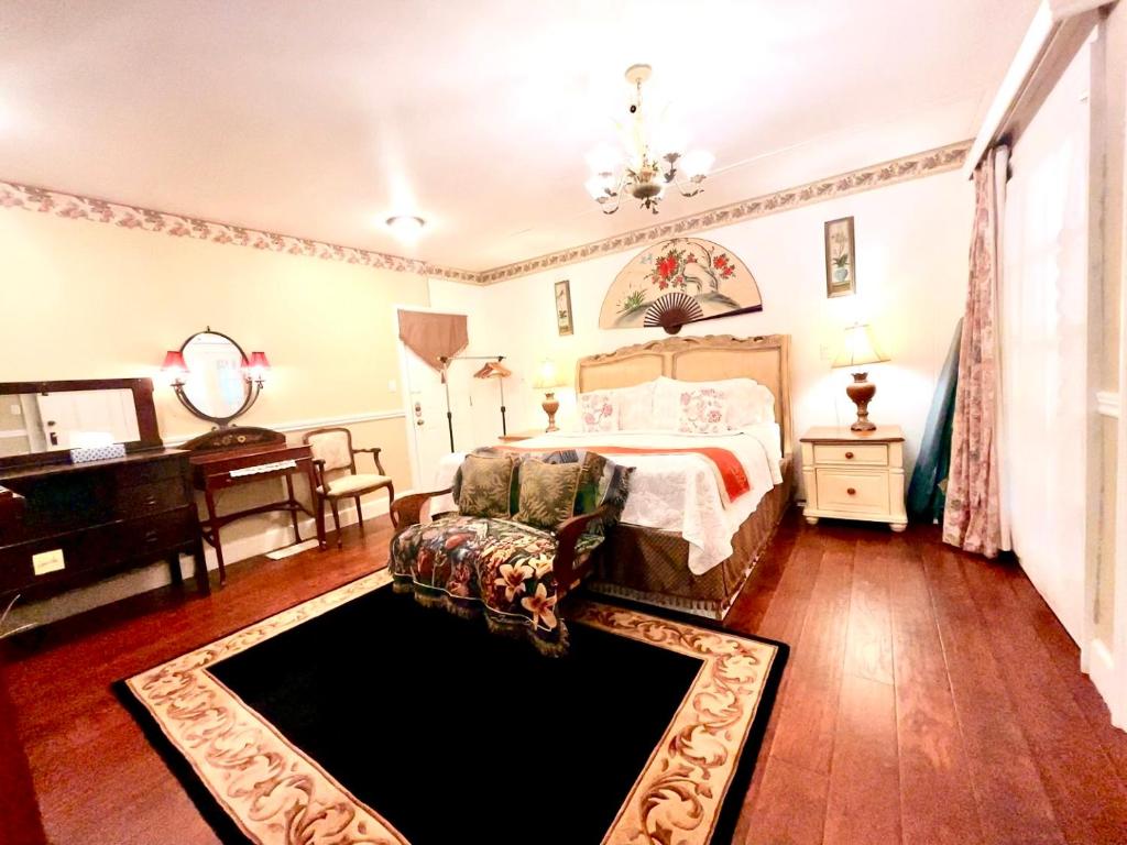 ein Schlafzimmer mit einem Bett, einem Stuhl und einem Klavier in der Unterkunft Apple & Cherry Suite-heart of oldtown in Niagara on the Lake