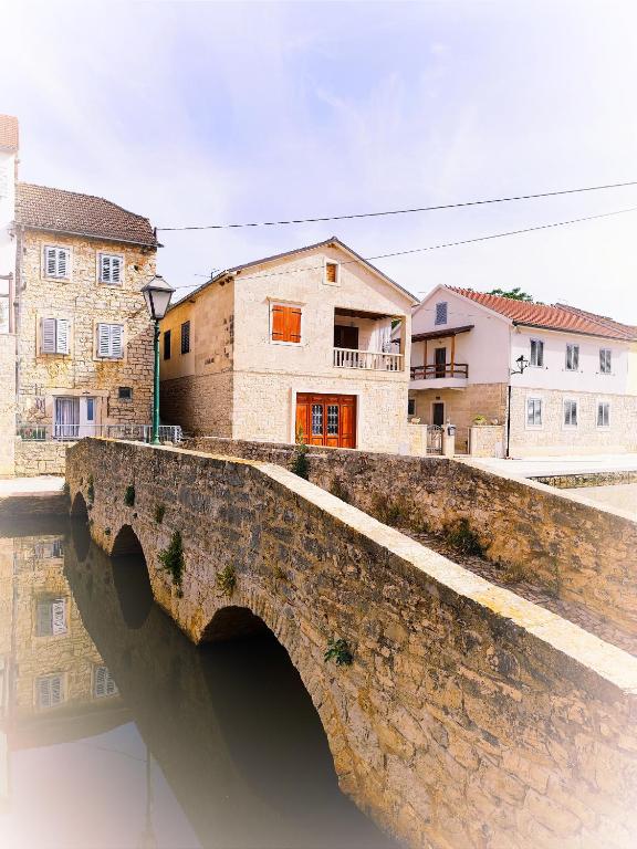 a bridge over a river with buildings in the background at Vetus pontem in Vrboska