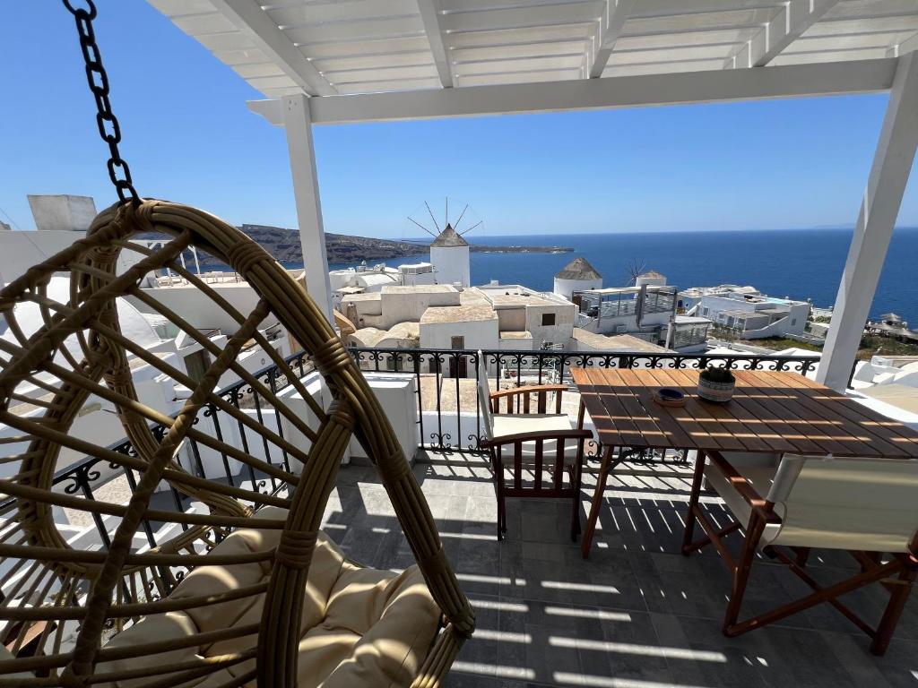 patio con mesa y sillas en el balcón en Sunset view apartment, en Oia