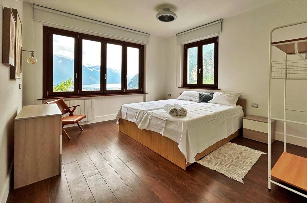 1 dormitorio con 1 cama grande y 2 ventanas en Garda View Apartment, en Tenno