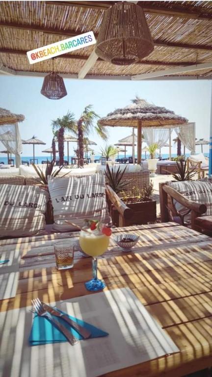 une table avec un verre au sommet d'une plage dans l'établissement La Villa Marcel, au Barcarès