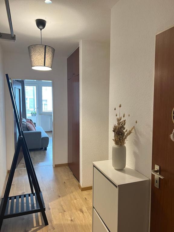 una sala de estar con una escalera y un jarrón en un armario en Düs Apartment 1, en Düsseldorf
