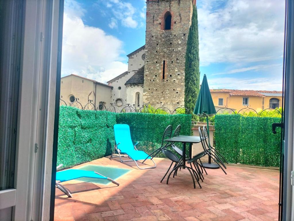 eine Terrasse mit Stühlen und einem Tisch vor einem Gebäude in der Unterkunft Fabroniana Apartments in Pistoia