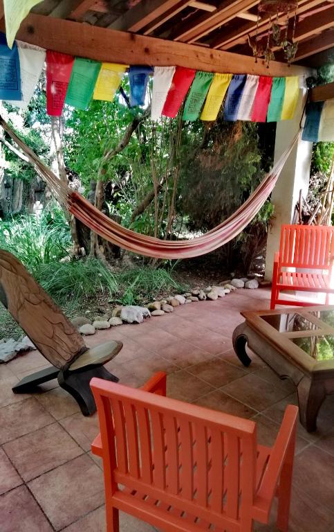 d'une terrasse avec un hamac, des chaises et une table. dans l'établissement Bulle de paix en Provence, à Bras-dʼAsse