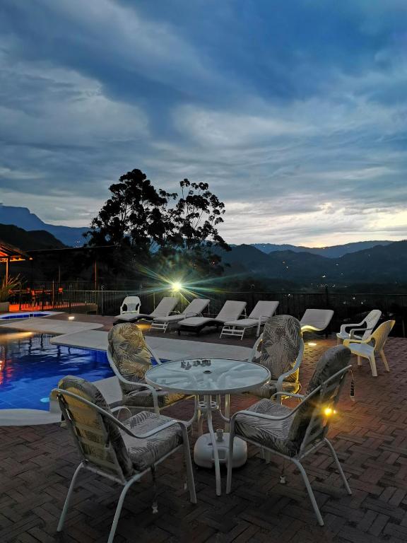 a patio with a table and chairs next to a pool at Acaima Café Lodge in Sasaima