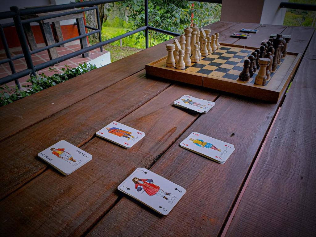 a chessboard and playing cards on a wooden table at Acaima Café Lodge in Sasaima