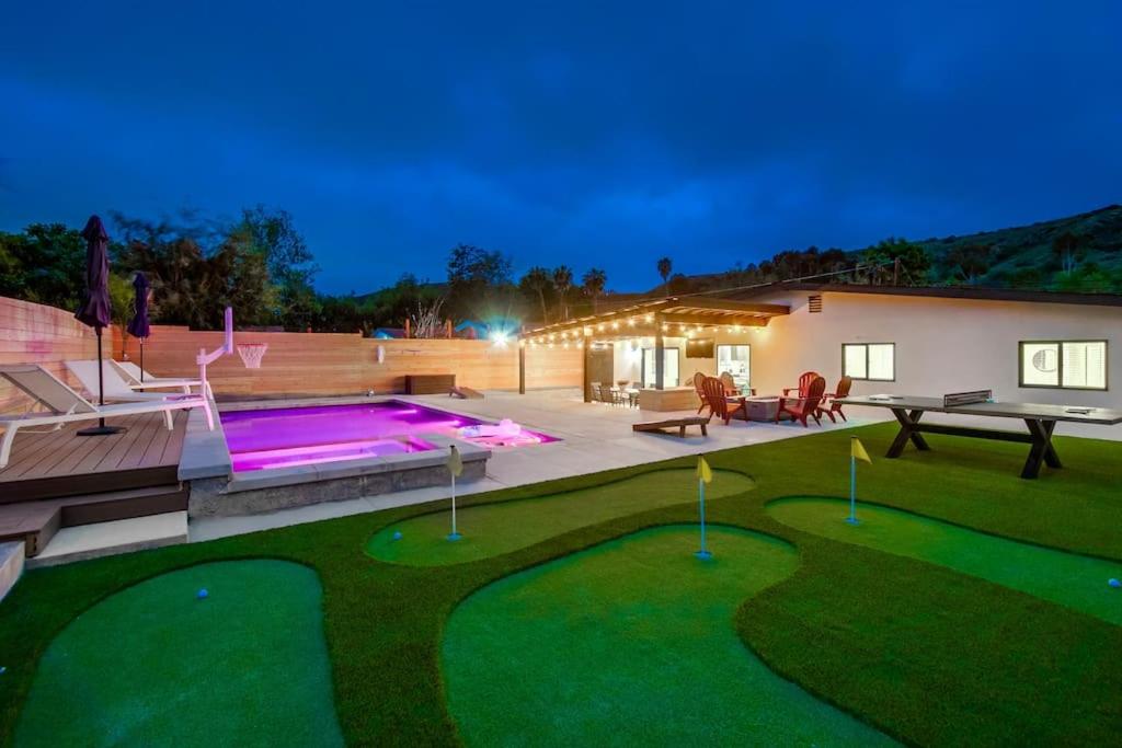 a backyard with a swimming pool and a patio with a table at 5BR Oasis - Pool, Hot Tub & Luxe Outdoor Retreat in Santee