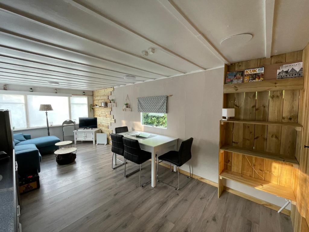 a living room with a table and chairs at Chalet Friesland H17 - 5 pers in Westergeest