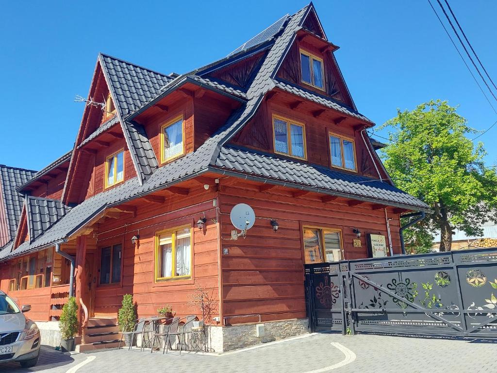 una gran casa de madera con techo de gambrel en Pokoje Gościnne „U Ani", en Małe Ciche