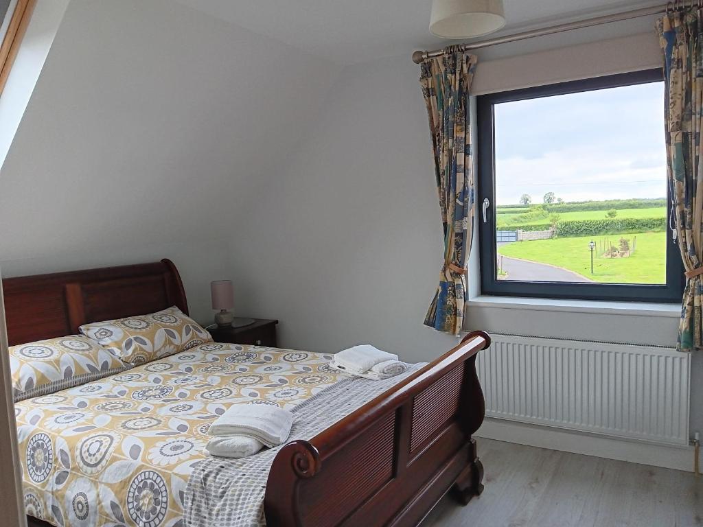 ein Schlafzimmer mit einem Bett und einem großen Fenster in der Unterkunft Duplex/2 Bedrooms on Kildare/Carlow/Laois Border in Carlow