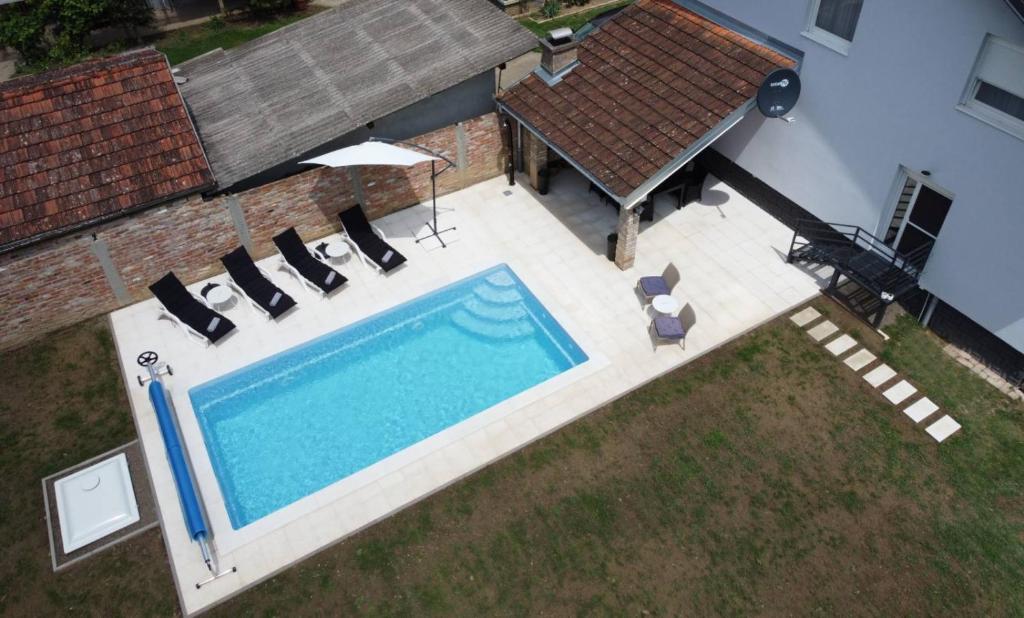een uitzicht op een zwembad met stoelen en een huis bij Villa Sorella Baranja in Karanac
