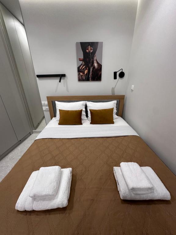 een slaapkamer met een groot bed en 2 handdoeken bij Smart Lux Apartment A in Athene