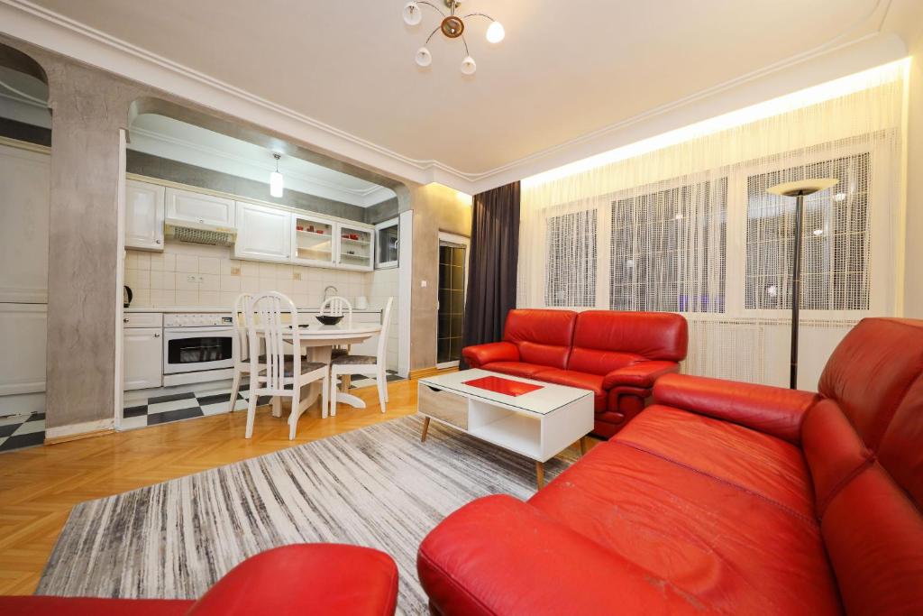 sala de estar con sofá rojo y cocina en Apartament Erisa en Peje