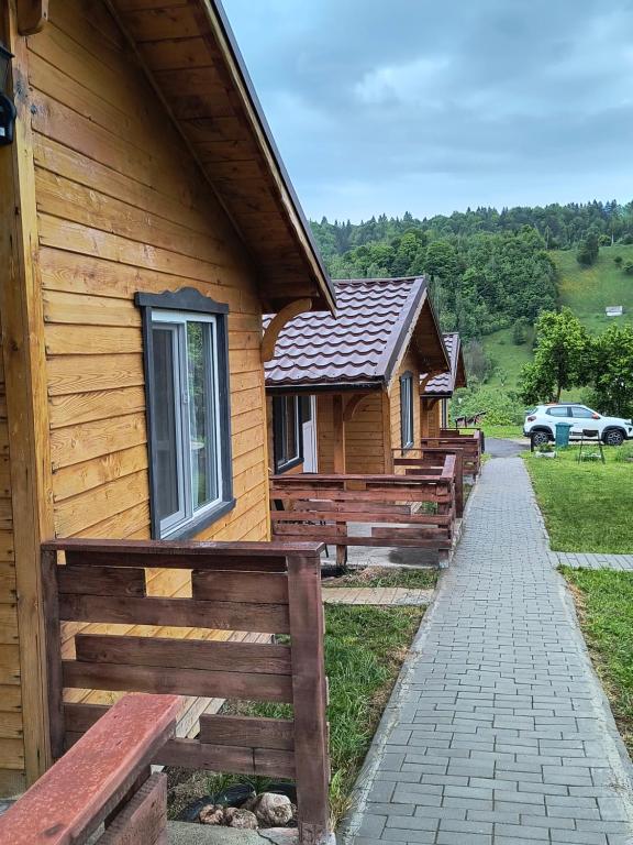 eine Reihe von Cottages aus Holz neben einem Gebäude in der Unterkunft Cabanute Luca Ama Bran in Braşov