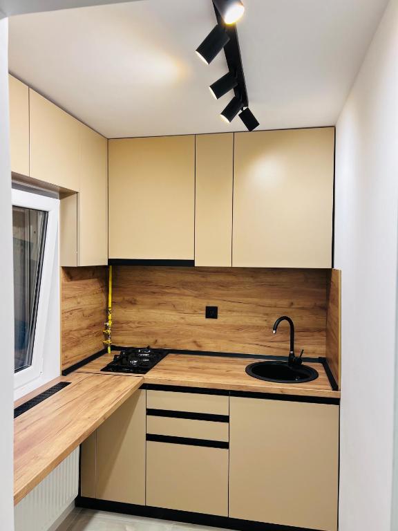 a kitchen with white cabinets and a sink at IMPERIUM DK STUDIO in Giurgiu