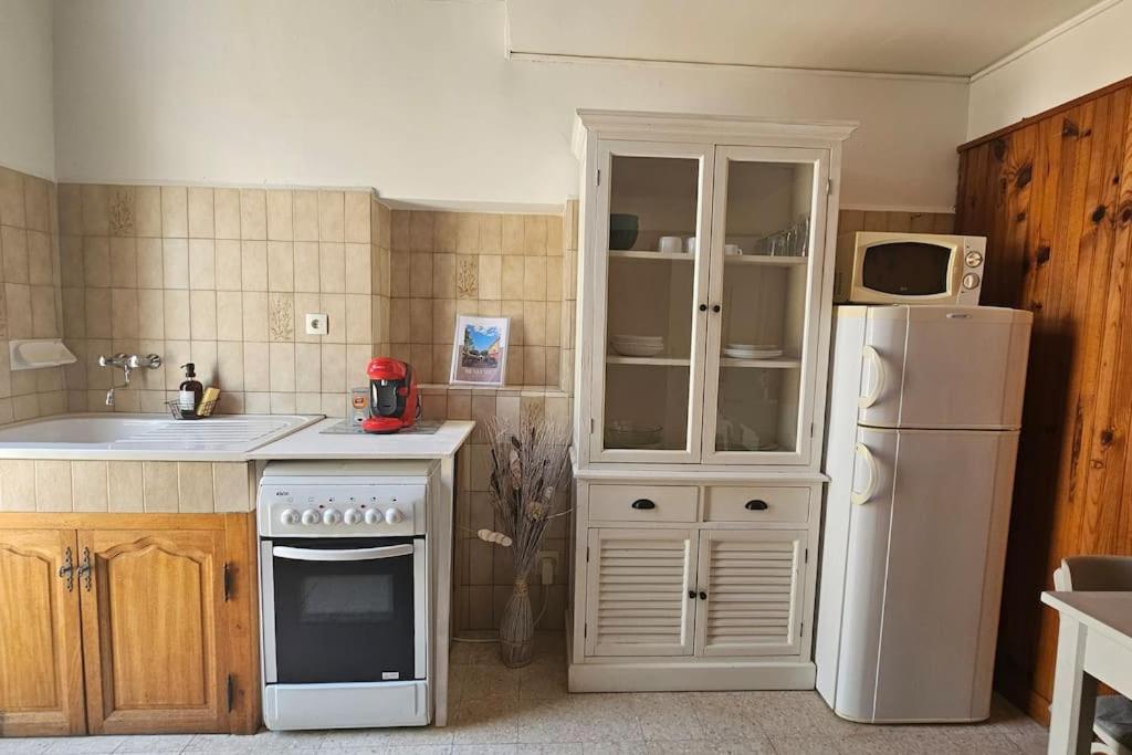 La cuisine est équipée d'un réfrigérateur blanc et d'un four micro-ondes. dans l'établissement Appartement Le Muy, au Muy