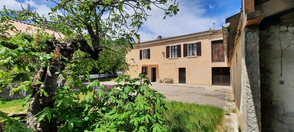 an old building with a tree in front of it at La ferme d'Yvette et Zou, au coeur des Baronnies Provencales, pour un séjour en famille ou entre amis in Barret-sur-Meouge