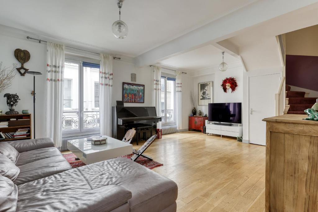 un salon avec un canapé et une télévision dans l'établissement Large Duplex Flat in a Courtyard - Trendy Paris 10, à Paris