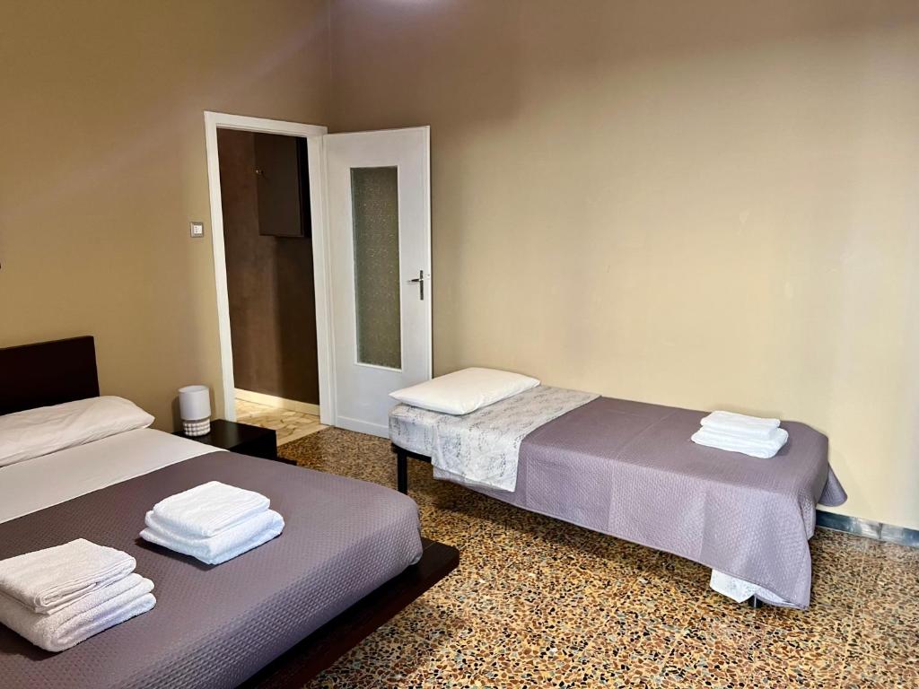 dos camas sentadas una al lado de la otra en una habitación en Bononia Host - Beverara, en Bolonia