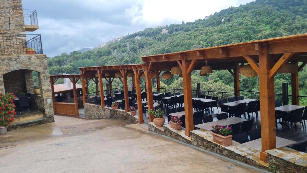 un patio avec tables et chaises sur une montagne dans l'établissement A COSTA, à Venzolasca