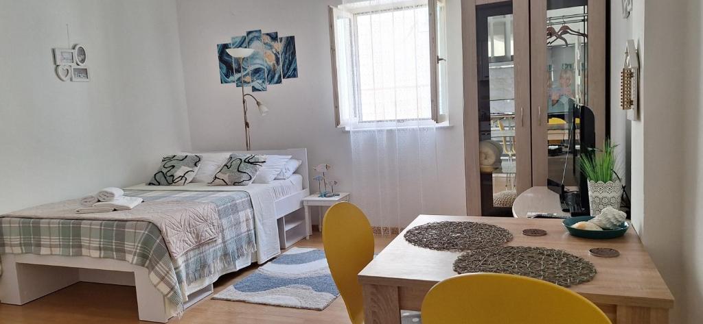 a bedroom with a bed and a table and chairs at Rooms & studio OLD TOWN PAG in Pag