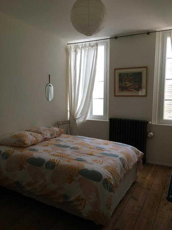 a bedroom with a bed and a window at La maison de Dom in Cognac