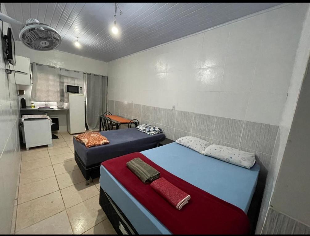 ブラジリアにあるHospedaria Cmc unidade 12のベッド2台とキッチンが備わる小さな客室です。