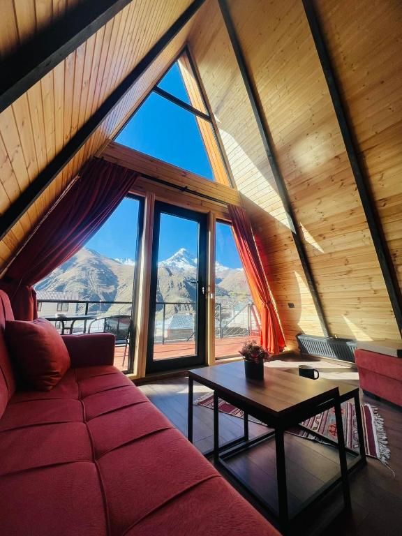 un soggiorno con un divano rosso e un tavolo di Pyramid Kazbegi a Kazbegi