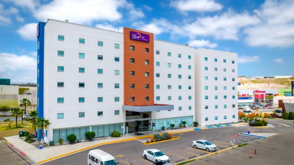 un edificio blanco con un letrero púrpura. en Sleep Inn Tijuana en Tijuana