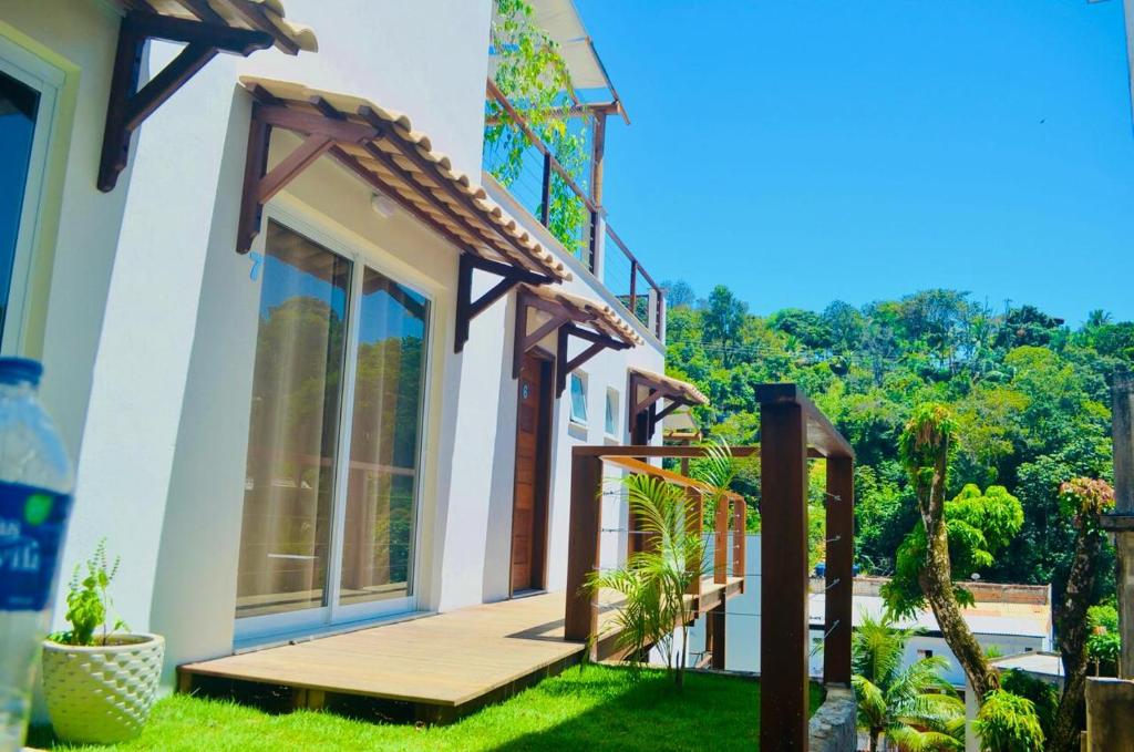 een huis met een houten veranda met een glas-in-loodraam bij Doce Lar Hospedagem Morro de são Paulo in Cayru