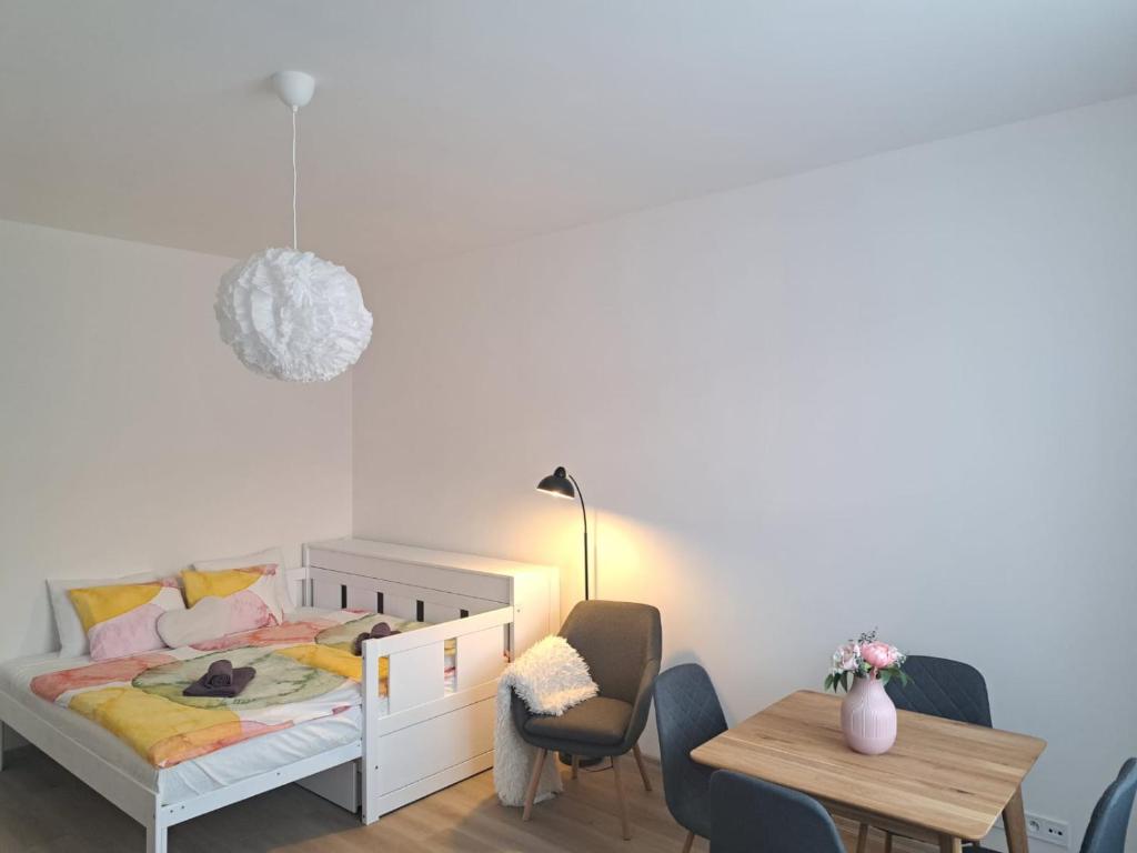 sypialnia z łóżkiem, stołem i krzesłami w obiekcie Studio-Apartment near Congress Centre Prague w Pradze