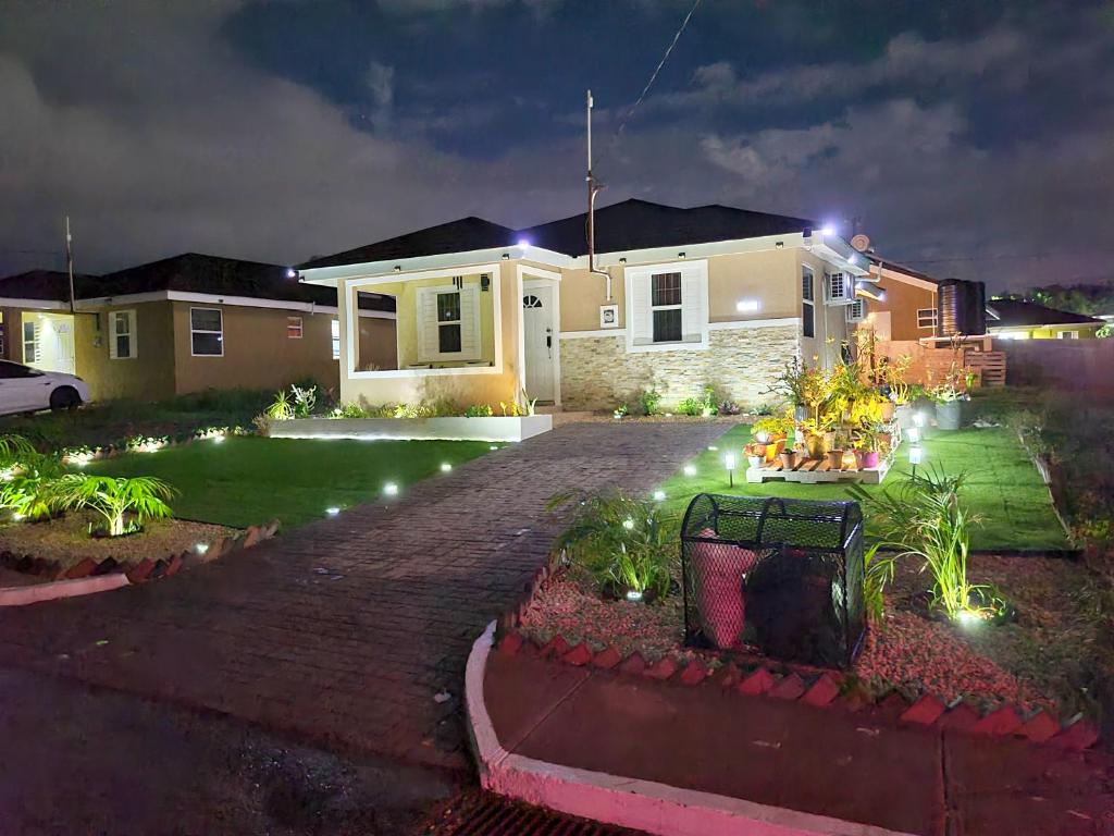 a house with lights in a yard at night at The Surada Bay in Old Harbour