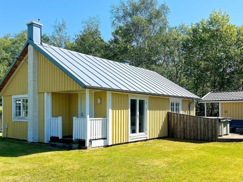 a yellow building with a fence in a yard at 6 person holiday home in LAHOLM-By Traum in Laholm
