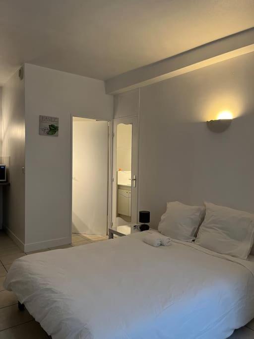 - une chambre avec un grand lit blanc dans l'établissement Studio 8 - Bord de Loire, à Orléans