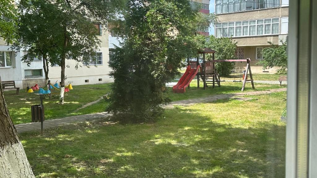 um parque com um parque infantil com um baloiço em Apartament BD 54 em Roman