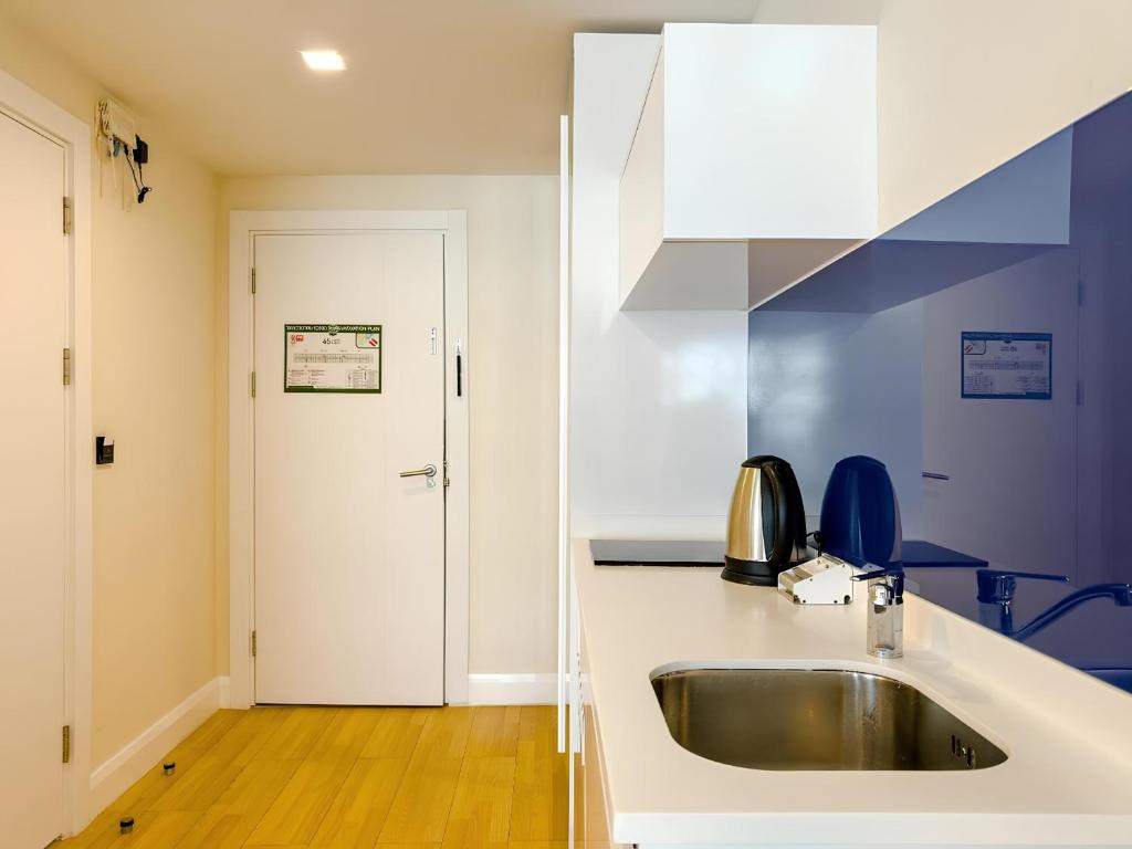 Orbi City apartment with sea view في باتومي: مطبخ مع بالوعة وقمة بيضاء